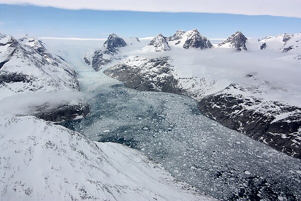 A glacier in eastern Greenland flowing through a fjord carved by the movement of ice