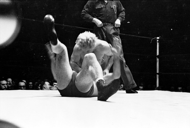 George attempting to pin another wrestler during a match, 1949