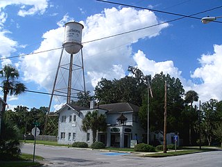 Two-story corner building with a water tower behind it