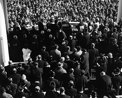The Inauguration of John F. Kennedy as seen from behind. The few top hats in the crowd can be distinguished by the shininess of the hat's flat crown