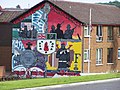 Mural en Bangor. En la esquina inferior izquierda se conmemora la participación de las tropas norirlandesas en la Batalla del Somme, símbolo recurrente en el bando lealista.
