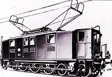 An Italian boxcab locomotive with prominent dual collectors for the three-phase twin-wire overhead system. Drive to the three coupled axles is taken by diagonal coupling rods from two central motors to jackshafts at the level of the axles, but beyond the coupled wheelbase. Twin axled bogies at each end are needed to support the weight of these jackshafts.