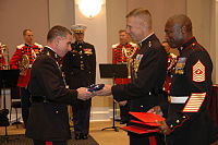 LtGen Huly receives an American flag from CMC General Hagee while the Sergeant Major of the Marine Corps John L. Estrada looks on. LtGen Huly receives the colors from CMC Gen Michael Hagee.jpg