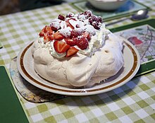 The meringue-based pavlova is generally eaten at Christmas time. Pavlova garnished with cream and strawberries.jpg