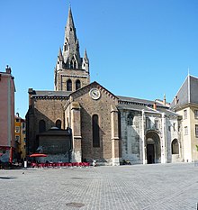 Foto.  Iglesia de ladrillo, campanario con aguja de toba.