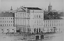 Foto: fasade av en operabygning ved bredden av Vltava