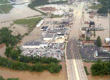Aerial view of flooded businesses along a thoroughfare.
