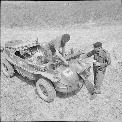 Men of the 23rd Hussars, 11th Armoured Division, painting divisional and arm of service markings on a German Schwimmwagen captured from the 12th SS Pa