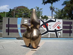 Escultura de Jean Arp. Título: Pastor de nubes. Autor: Jean Arp. Año: 1953. Ubicación: Al oeste de la Plaza Cubierta. Al fondo se ve el bimural de Mateo Manaure.