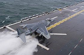 Un Harrier de l'US Marine Corps effectue un décollage court sur un pont d'envol trempé.