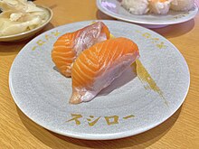 Two pieces of salmon sushi on a silver plate bearing the words "Sushiro".
