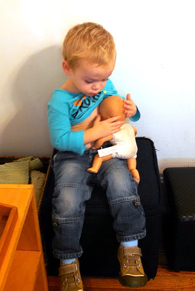 File:A boy playing, nursing his doll.jpg