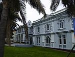 This double storey building was built to house the Atheneum Club, an institute founded in the early days of Port Elizabeth to promote cultural activities. The Belmont Terrace facade has two wings, joined by a central arched entrance porch with classical This late Victorian building, with its impressive neoclassical elements, consists of two sections, which were opened in 1896 and 1901 respectively. Architectural style: Edwardian Baroque. Type of site: Club.