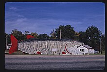 large building-sized wooden structure shaped like a striped fish