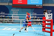 Deutsch: Boxen bei den Olympischen Jugendspielen 2018 Tag 12, 18. Oktober 2018 - Kampf um Bronze im Leichten Weltergewicht Jungen – Hassan Azim (Großbritannien, rot) schlägt Mohammed Boulaouja (Marokko, blau) RSC; Ringrichter ist Wulfren Olivares Peréz (Kolumbien). English: Boxing at the 2018 Summer Youth Olympics on 18 October 2018 – Bronze Medail Match Light Welterweight Boys - Hassan Azim (Great Britain, red) beats Mohammed Boulaouja (Morocco, blue) RSC; Referee is Wulfren Olivares Peréz (Columbia). Español: Boxeo en los Juegos Olímpicos Juveniles de Verano de 2018 en 18 de octubre de 2018 - Medalla de bronce de los hombres ligeros de peso welter: Hassan Azim (Gran Bretaña, rojo) vence a Mohammed Boulaouja (Marruecos, azul) RSC; El árbitro es Wulfren Olivares Peréz (Colombia).