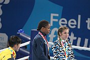 Deutsch: Boxen bei den Olympischen Jugendspielen 2018 Tag 12, 18. Oktober 2018 - Medaillenzeremonie im Leichtgewicht der Mädchen - Gold: Caroline Sara DuBois (Großbritannien), Silber: Porntip Buapa (Thailand), Bronze: Oriana Saputo (Argentinien); Medaillenübergabe durch Habu Gumel (IOC, Nigeria), Geschenkübergabe durch Raymond Silvas (USA, AIBA). English: Boxing at the 2018 Summer Youth Olympics on 18 October 2018 – Girl's Lightweight Medal Ceremony - Gold: Caroline Sara DuBois (Great Britain), Silver: Porntip Buapa (Thailand), Bronze: Oriana Saputo (Argentina); Medal handover by Habu Gumel (IOC, Nigeria), Gift presented by Raymond Silvas (USA, AIBA). Español: Boxeo en los Juegos Olímpicos Juveniles de Verano de 2018 en 18 de octubre de 2018 - Ceremonia de la Medalla de peso ligero para niñas - Oro: Caroline Sara DuBois (Gran Bretaña), Plata: Porntip Buapa (Thailand), Bronce: Oriana Saputo (Argentina); Entrega de medallas por Habu Gumel (COI, Nigeria), Regalo presentado por Raymond Silvas (EE. UU., AIBA).