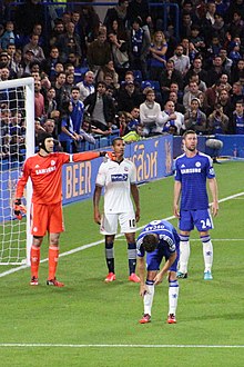 Beckford (wearing white) playing for Bolton Wanderers against Chelsea in the League Cup in 2014 Chelsea 2 Bolton Wanderers 1 Chelsea progress to the next round of the Capital One cup (15328794156).jpg