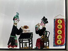 Chinese shadow puppetry is a form of theater whereby colorful silhouette figures perform traditional plays against a back-lit cloth screen, accompanied by music.From Kaifeng Prefecture. Chinese shadow puppetry.jpg