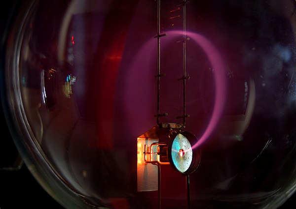 Beam of electrons moving in a circle, due to the presence of a magnetic field. Purple light revealing the electron's path in this Teltron tube is crea