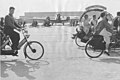 Deelnemers aan de Tandemdag Schiphol fietsen over het platform, 1936.jpg