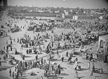 Groups of Halaqi formed around the artists of the Halqa in Jemaa El Fna square in Marrakesh in the years 1930-31 ETH-BIB-Marrakech-Den ganzen Tag herrscht reges Leben au dem Place Dyema (Jemaa) el Fna-Tschadseeflug 1930-31-LBS MH02-08-0448.tiff