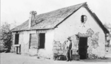 Old bathhouse at Encino hot mineral spring, shown with Alex Abel, caretaker of the Amestoy Ranch Encino Spring old bathhouse, prior to 1920.png