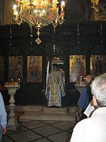 דיאקון ניצב בעת המיסה על המדרגה (אמבון) שבחזית האיקונוסטאזיס בכנסייה, בעת שהדלת הקדושה מאחוריו פתוחה