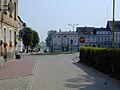 Polski: Karlino; fragment Placu Jana Pawła II z drogą prowadzącą w kierunku Białogardu