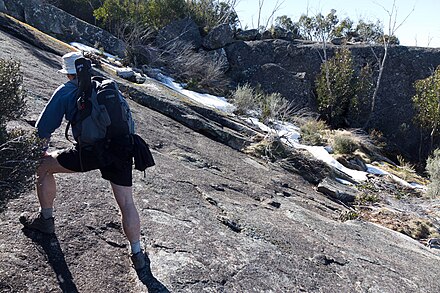 A trekker climbing up Mount Gudgenby