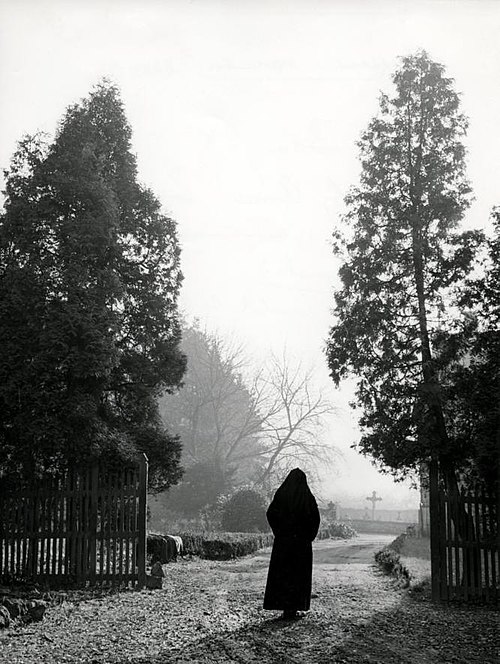 Nun visiting a graveyard at All Souls' Day