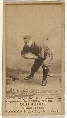 Man in baseball uniform bending down