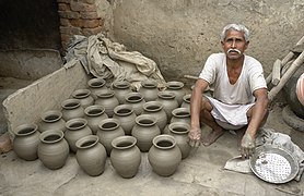 Potter and his work, Jaura, India.jpg