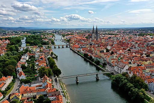Regensburg (Luftbild). Blick ostwärts, links der Stadtteil Stadtamhof, rechts die ALtstadt Regensburg. Über den südlichen Donauarm führen der Eiserne Steg (vorne) und Steinerne Brücke (hinten)