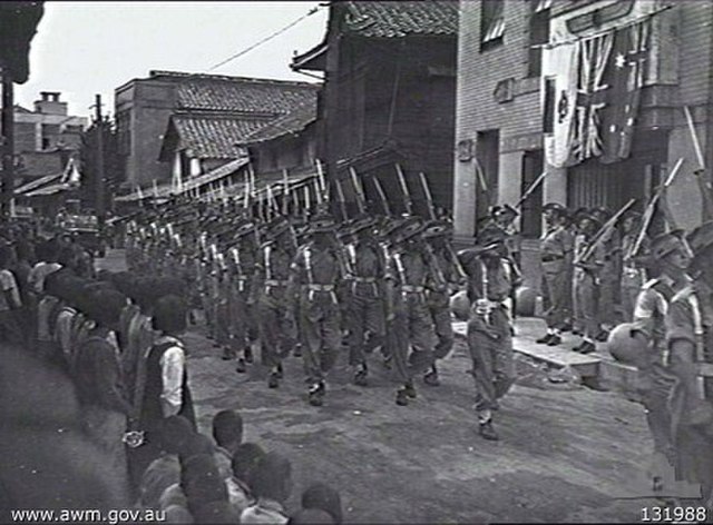 Troops from the 34th Brigade march through Saijo in 1946