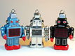 दिखाऊ - तीन खिलौने रोबोट्स का चित्र