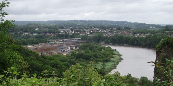 View taken in 2011 towards the site of National Shipyard No.1 at Chepstow. The shipyard was in the area covered by the factory buildings and overgrown slipways in the centre of the photograph. Shipyard site chepstow cropped.jpg