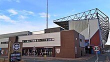 A brick-walled building which contains the club shop. It is located between two large stands.