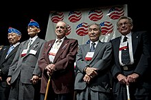 U.S. Army veterans from the 141st Infantry Regiment and the 442nd Regimental Combat Team stand during the 65th anniversary tribute dinner for the veterans of the Rescue of the Lost Battalion in Houston, Texas (November 2009). U.S. Army veterans from the 141st Infantry Regiment and the 442nd Regimental Combat Team stand during the 65th Anniversary Tribute dinner.jpg