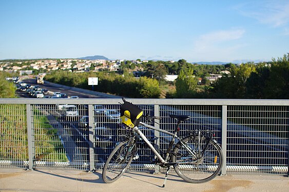 Un vélo sur un pont au dessus des bouchons