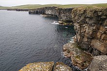 West coast of Westray Looking along the sandstone cliffs to the rock arch at Neven o'Grinni