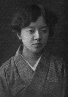 A young Japanese woman with dark wavy hair, wearing a kimono