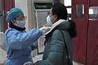 A nurse measuring the body temperature for outpatients in Hubei TCM Hospital.jpg