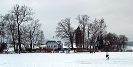 A frozen lake with people ice-skating upon it