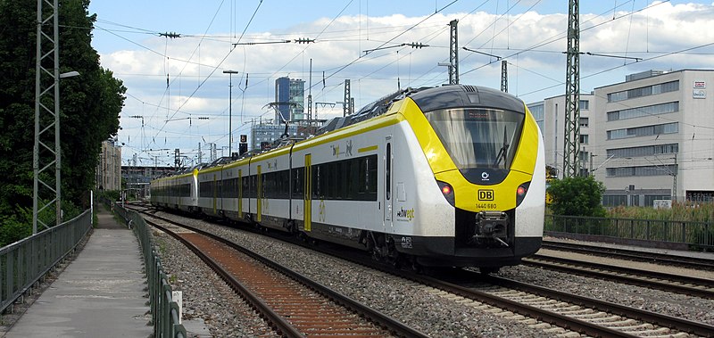 File:Alstom Coradia auf der Höllentalbahn, im Hintergrund der Freiburger Hauptbahnhof, rechts die Bürogebäude.jpg