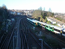 Northbound and southbound Southern trains pass under the Dyke Road Drive over bridge, north of the Montpelier Sidings on the Brighton Main Line. Dyke Road Drive 2.jpg