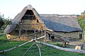 Photographie montrant un bâtiment en pierres recouvert de chaume.