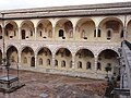 Assis, Sacro Convento, claustro de Sisto IV com, em ambas as ordens, as janelas românicas do antigo edifício (século XIII) e o que resta dos afrescos do século XVI de Dono Doni e seu filho Lorenzo.