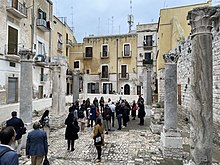 Grupos de turistas visitando ruínas en Bari (Italia).
