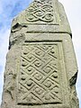 English: The Broken Cross is one of the five high crosses in Kells, County Meath, Ireland. It may have been the tallest high cross ever. It may have been broken by Oliver Cromwell's army, which used the church as stables. Here is the top of the southern face. Français : La Croix brisée est l’une des cinq hautes croix de Kells, ville irlandaise du comté de Meath. Elle a peut-être été la plus imposante haute croix. Elle aurait été brisée par les armées d’Oliver Cromwell, qui stationnaient leurs chevaux dans l’ancienne église. Ici, on voit le haut de la face sud.