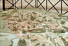 Model of archaic Rome. The image faces northeast, with the Capitoline hill on left and the Palatine on right. The city would not have looked like this prior to the seventh century BC. Maquette de la Rome archaique (musee de la civilisation romaine, Rome) (5917668745).jpg